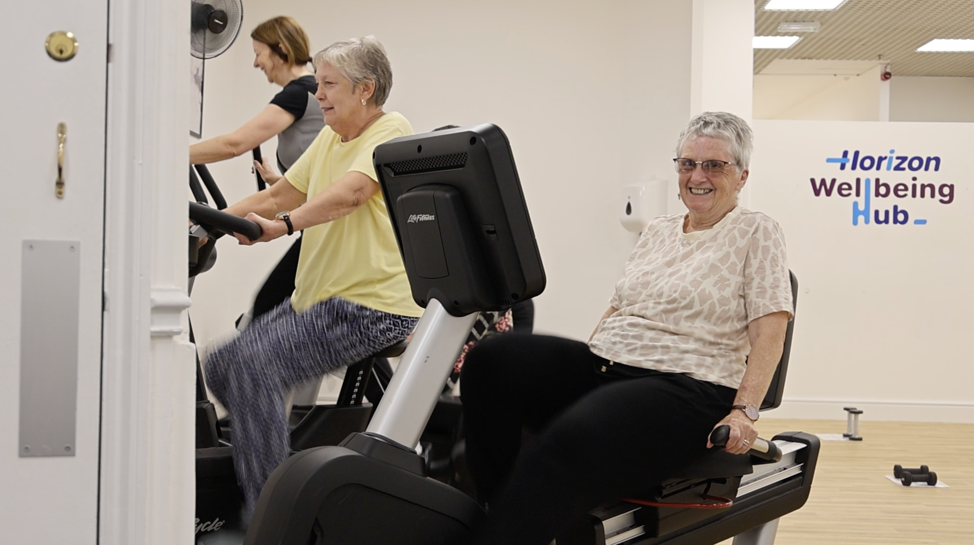 a group of ladies on exercise bikes at the Wellbeing Hub