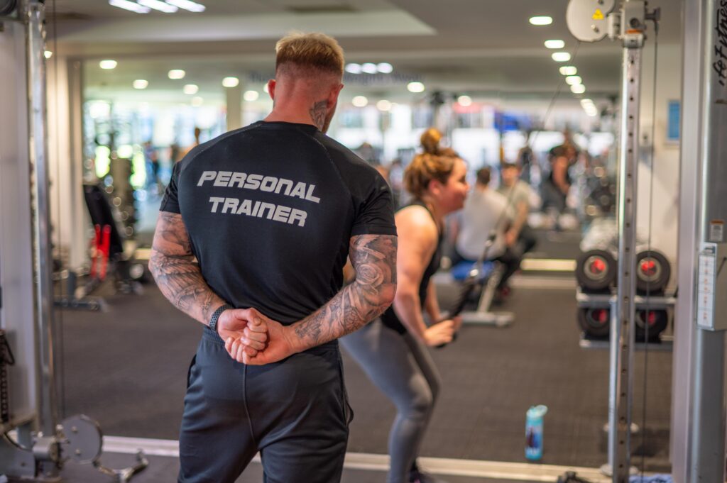 a PT and woman in a gym