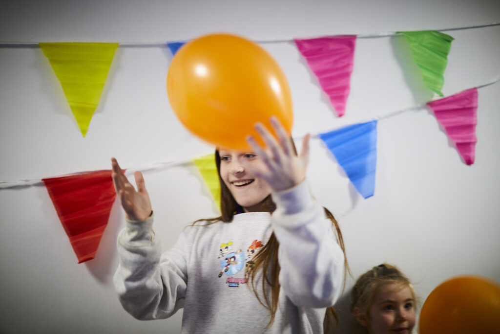 a girl holding a balloon at a Horizon birthday party