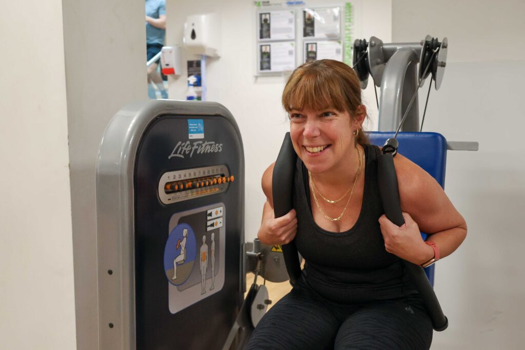 a woman smiling whilst exercising at Horizon gym