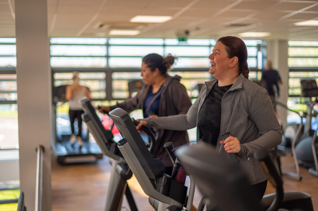 Two people working out in the gym together to promote our bring a friend offer this International Women's Day.