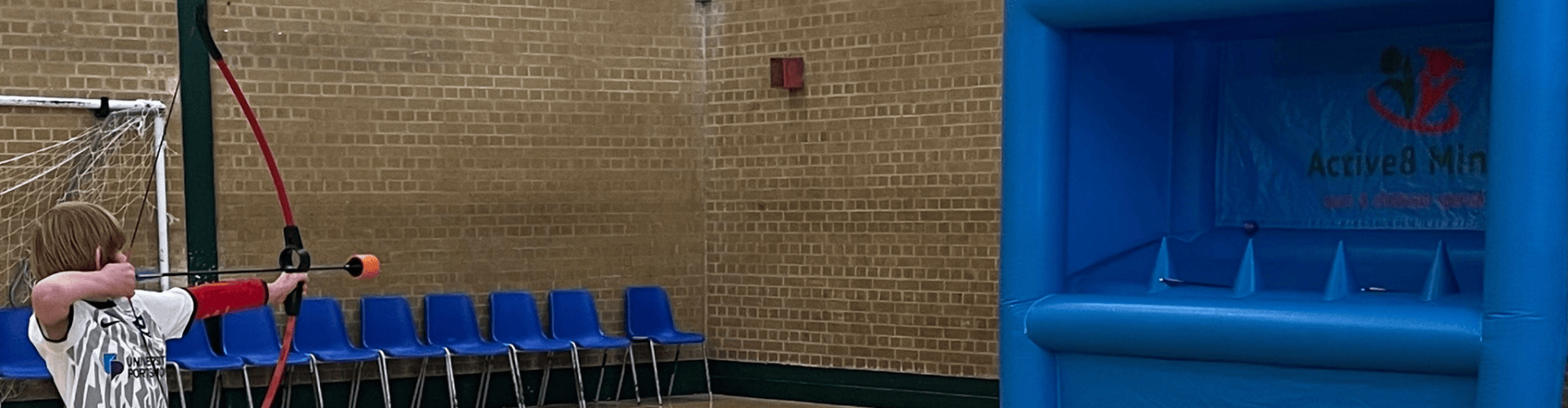 Active8 Minds holiday club playing inflatable archery at Horizon Havant's sports hall
