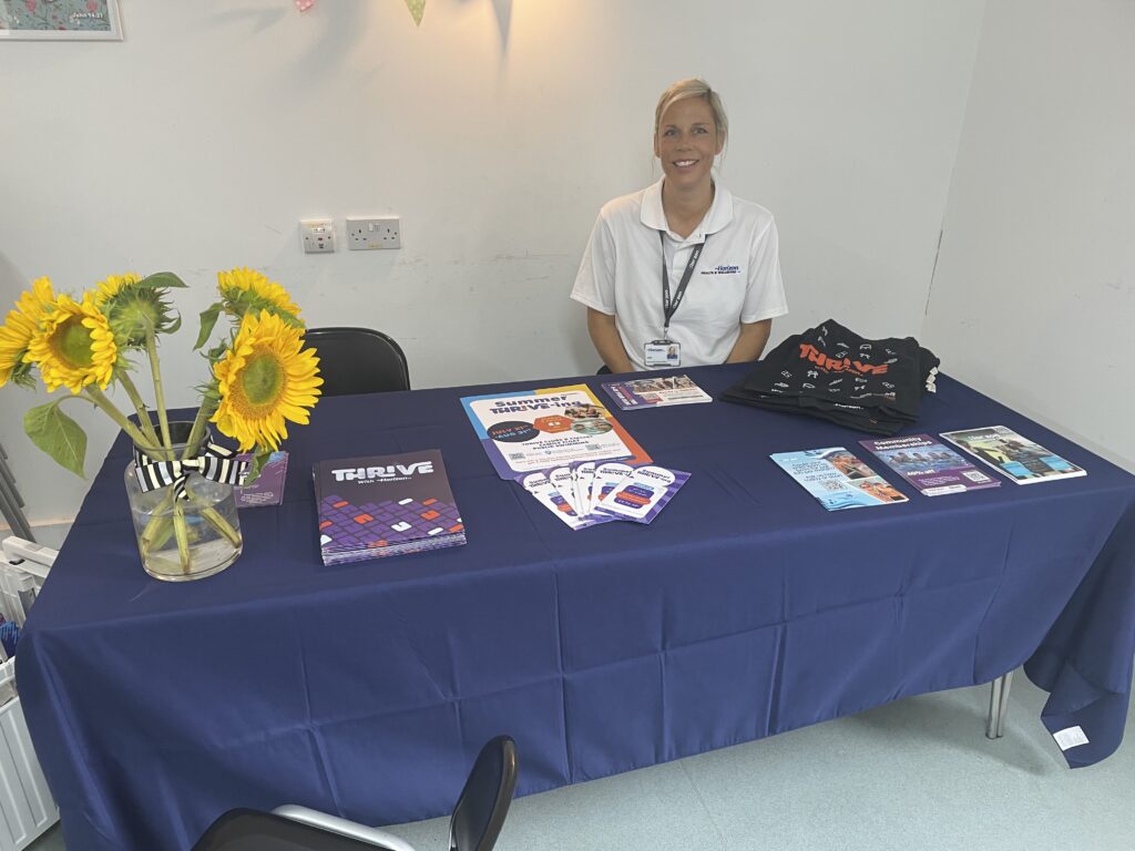 Table with brochures and sunflowers promoting SEND.