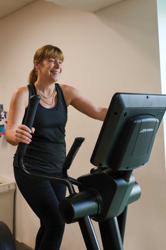Woman exercising on a machine at a gym in Guildford