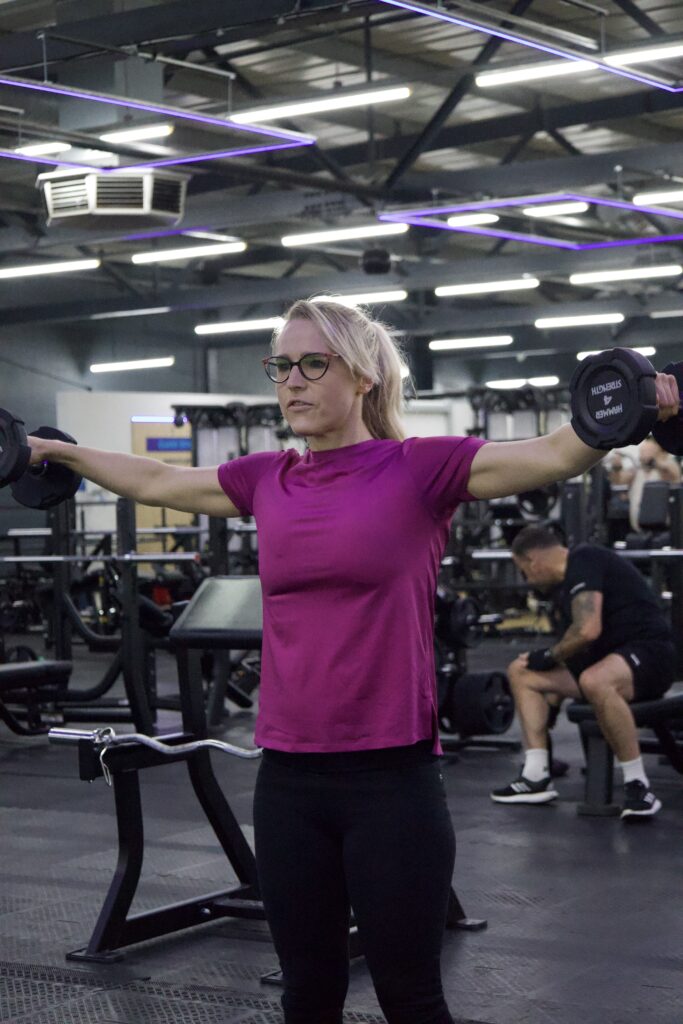 Woman lifting weights in gym strength training