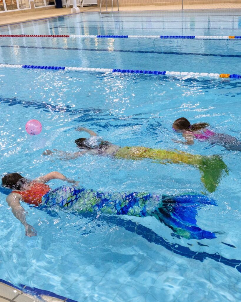 Children swimming in colourful mermaid tails october half term