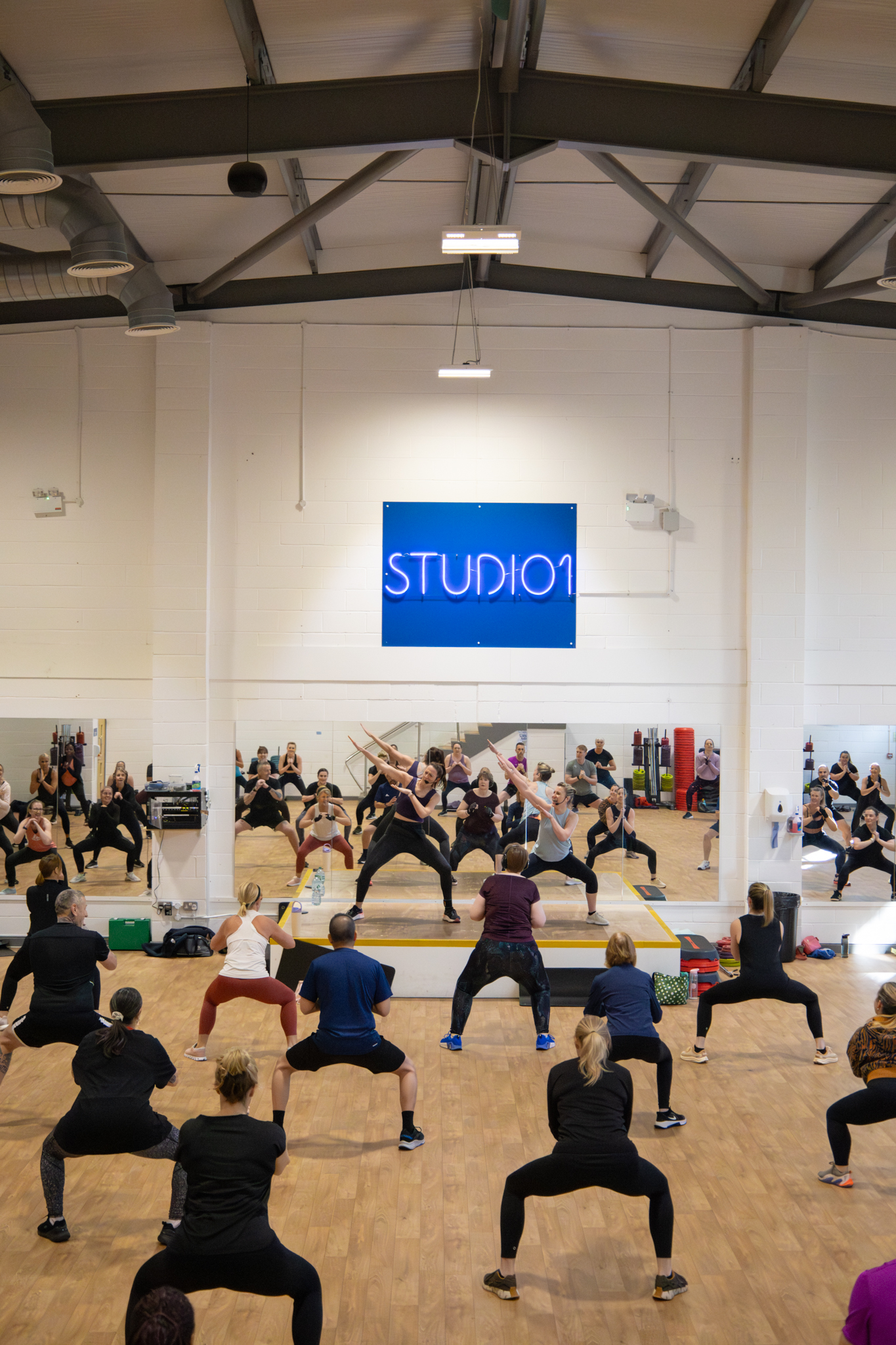 Group exercise class in studio setting. may opening hours